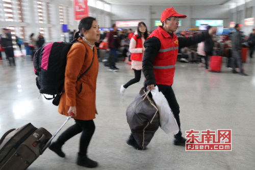 志愿者為旅客提供服務 施建清/攝