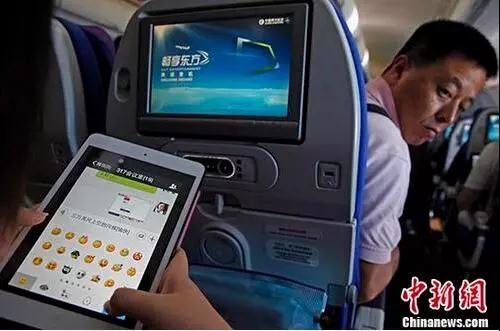 乘客在飛機上使用微信。圖片來源 <a target='_blank'  >中新網</a>