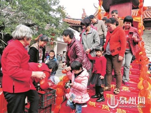 市民、游客過(guò)平安橋領(lǐng)紅蛋。