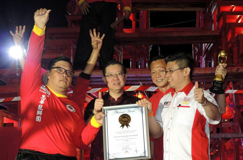 黃楓偉( 右一) 在林冠英(左二)見(jiàn)證下，頒發(fā)證書(shū)和獎(jiǎng)杯給馮家俊(左一)及楊筌貴(右二)。(圖：星洲日?qǐng)?bào))