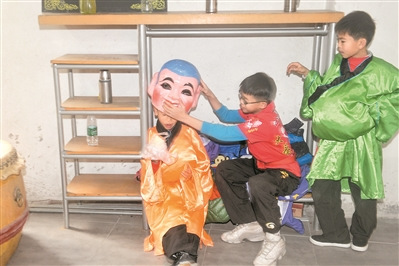 學(xué)習(xí)了一個(gè)上午的大頭佛表演，小學(xué)徒在一旁休息。