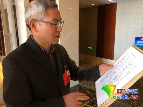 　全國政協(xié)委員賀云翱發(fā)起這份聯(lián)合提案，圖為提案最終遞交前他向記者介紹簽名情況。中國青年網(wǎng)記者 吳楚 攝