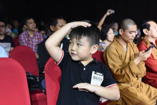一位華裔小朋友在臺下模仿武僧運(yùn)氣。
