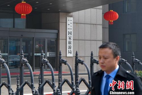 3月13日下午，一名男子從國家旅游局大門前走過。當日，《國務院機構改革方案》提請十三屆全國人大一次會議審議。方案提出，組建文化和旅游部，不再保留文化部、國家旅游局。<a target='_blank' >中新社</a>記者 駱云飛 攝