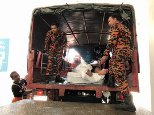 華裔男子被抬上卡車送往醫(yī)院。（馬來西亞《中國報(bào)》）