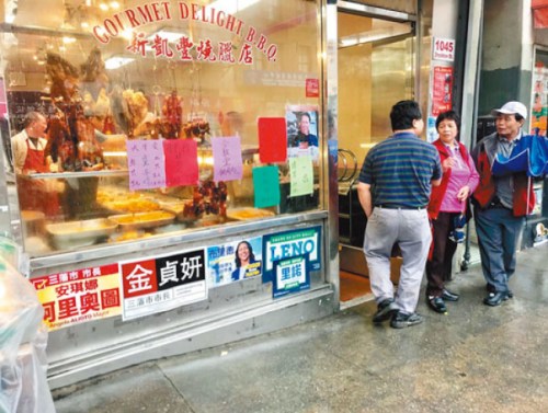 華埠市德頓街某燒臘店門前并排張貼了四名熱門候選人布里德、里諾、金貞妍、阿里奧圖的競選廣告。 (美國《世界日報(bào)》/黃少華 攝)