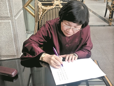 周功鑫在給廣州日?qǐng)?bào)讀者寫寄語。
