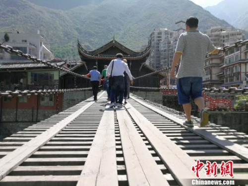 圖為海外華文媒體代表走過(guò)瀘定橋?！钭谂?攝