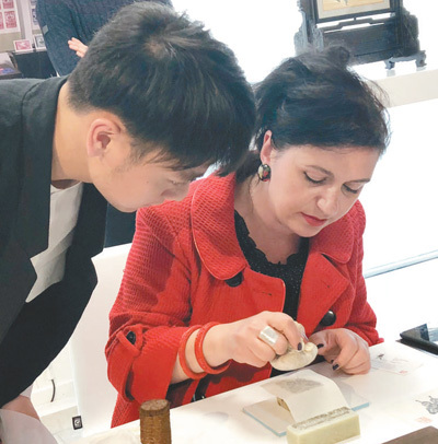 在倫敦手工藝周“技藝中國”展上，一位參觀者在體驗中國拓印工藝。本報記者 強 薇攝 