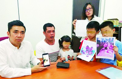 許羅全與3名稚齡子女盼望鄧春美早日回家團聚。左為方美錸、右為王育璇。(圖片來源：馬來西亞光華網(wǎng))