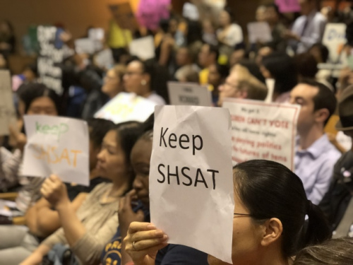 針對特殊高中改革，不少家長帶著抗議牌前往參加會議。(美國《世界日報》/黃伊奕攝)