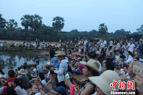 資料圖：國際游客守候在吳哥窟景區(qū)觀看日出?！×蚊艏?攝