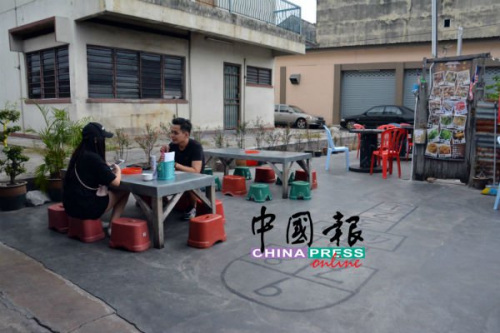 在祖屋前，與三兩好友蹲坐小凳存吃著鮮蛤，別具風(fēng)味。(馬來(lái)西亞《中國(guó)報(bào)》記者 趙詩(shī)綺 攝)