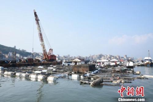 在受碳九泄漏影響的泉州市泉港區(qū)肖厝碼頭，起吊船對受損漁排進(jìn)行加固。陳龍山 攝