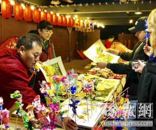 游客對中國傳統(tǒng)藝術刺繡和泥塑人偶充滿興趣。(美國《僑報》/翁羽 攝) 