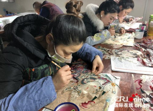 匠人給雕刻完成的皮影上色。攝影：張捷