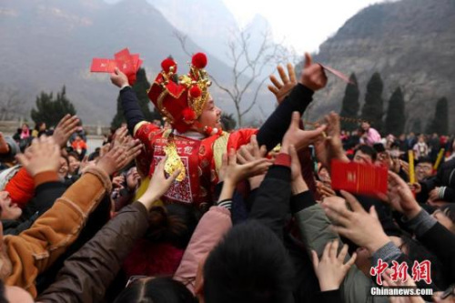 資料圖：“財(cái)神”向游客派發(fā)現(xiàn)金紅包。 王中舉 攝
