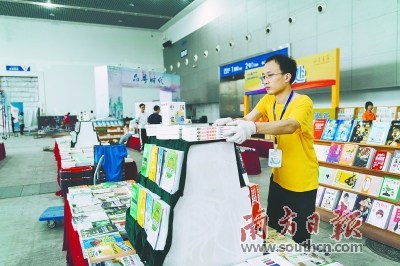 工作人員將書籍整齊地擺在展臺上 工作人員將書籍整齊地擺在展臺上