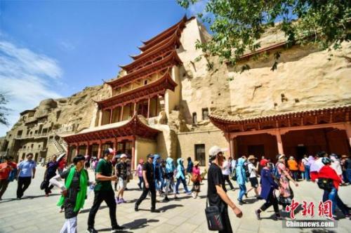 資料圖：莫高窟標(biāo)志性建筑“九層樓”前的游人如織。王斌銀 攝