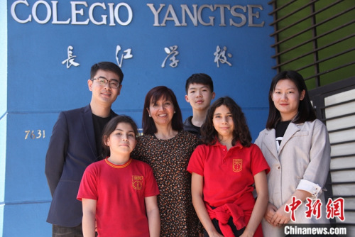 圖為11月6日，長江學(xué)校校長羅哈斯(Marcela Rojas Cantillana，左三)、國家漢辦駐智利漢語教師志愿者管理教師劉昌(左一)、長江學(xué)校中文老師李媛媛(右)與學(xué)生們在學(xué)校門前合影。<a target='_blank' >中新社</a>記者 余瑞冬 攝