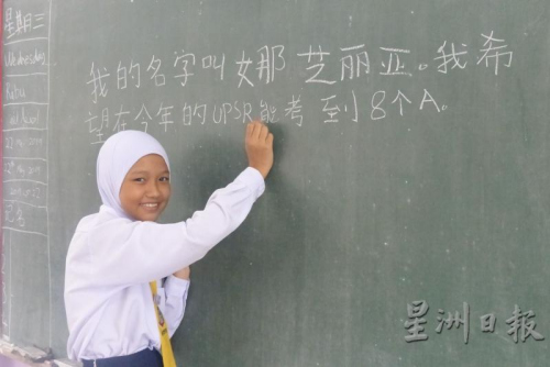 娜芝麗亞以工整的中文字體，在黑板上寫下自己的心愿。(來源：星洲日報)