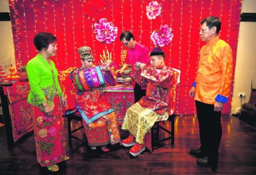 新郎的父親李榮佳(右一)在給兒子操辦婚禮時(shí)，特地前往馬六甲重金禮聘?jìng)鹘y(tǒng)婚禮禮儀師，而部分古董和珠寶是來(lái)自他個(gè)人及友人的收藏。多方奔走后，最終圓滿(mǎn)舉行了一場(chǎng)遵循傳統(tǒng)習(xí)俗的婚禮。 (新加坡《聯(lián)合早報(bào)》/梁麒麟 攝)