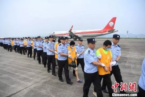  資料圖：警察在押回“殺豬盤”詐騙人員。(圖源：中國新聞網(wǎng))