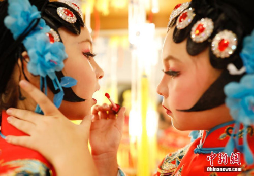 圖為演出前，姐姐幫妹妹化妝。<a target='_blank' >中新社</a>記者 劉關(guān)關(guān) 攝