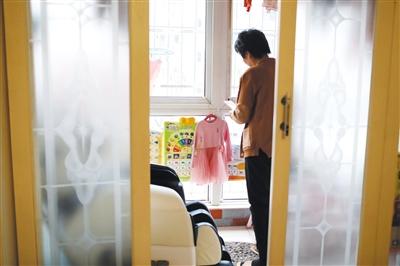 12月23日，天津?yàn)I海新區(qū)，好友要給張英2歲的女兒買新衣服，湯玉娥拍照給好友看現(xiàn)有的衣服樣式。