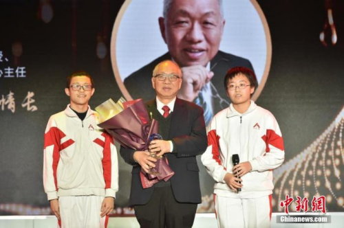 中國人民大學(xué)附屬中學(xué)的兩位同學(xué)為丘成桐獻(xiàn)上獎(jiǎng)杯，致敬杰出的華人數(shù)學(xué)家。<a target='_blank' >中新社</a>記者 翟璐 攝