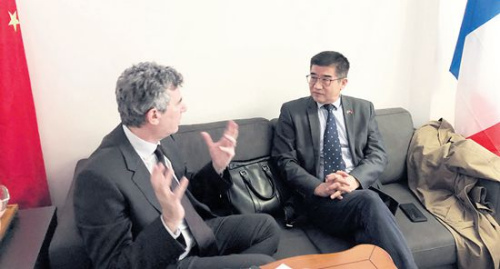 　　正在和客人商討前往中國計劃的周建防(右)。(《歐洲時報》/黃冠杰 攝)