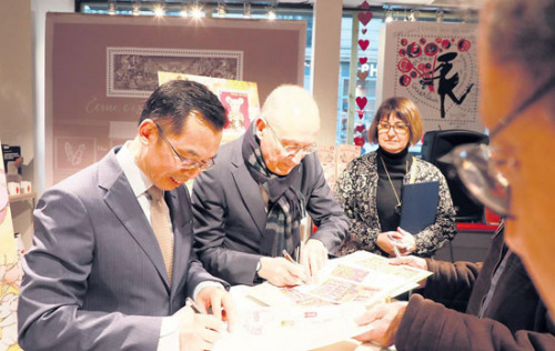 　　盧沙野大使(左)、菲利普·瓦爾總裁為集郵愛(ài)好者簽名留念。(《歐洲時(shí)報(bào)》/歐文 攝)