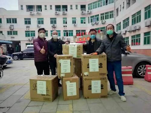 福清華僑中學(xué)日本校友會(huì)捐贈(zèng)的的防疫物資由福清市紅十字會(huì)交到福清華僑中學(xué)老師手上。(福清華僑中學(xué)供圖) 