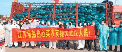 　　支援武漢的江蘇常熟菜農(nóng)及其他人員在運輸貨車前合影。（東敏佳供圖）