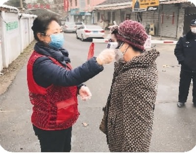 馬麗（左）為居民測量體溫。（馬 麗供圖）