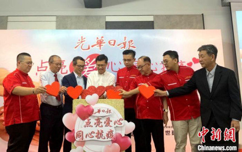 馬來(lái)西亞《光華日?qǐng)?bào)》為支持中國(guó)抗擊疫情舉辦的“點(diǎn)亮愛(ài)心，同心抗疫”義賣(mài)會(huì)。圖為開(kāi)幕儀式上，大家一同把“愛(ài)心”投進(jìn)愛(ài)心箱。　陳悅 攝