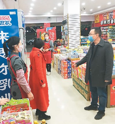 圖為楊姚春（右）在云南省保山市龍陵縣勐糯鎮(zhèn)的一家超市了解商品庫存情況。（李志鋒攝）