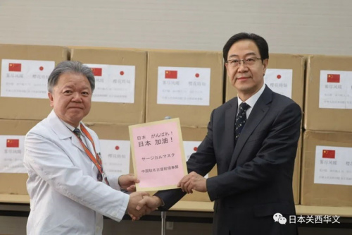 村上信五院長(zhǎng)(左)代表院方從劉曉軍總領(lǐng)事(右)手中接受捐贈(zèng)物資(日本《關(guān)西華文時(shí)報(bào)》微信公眾號(hào)/春平 攝)
