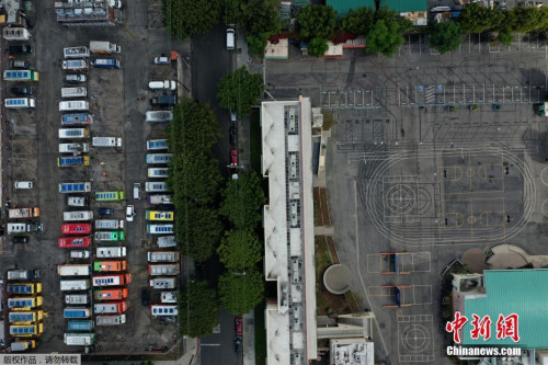 當(dāng)?shù)貢r(shí)間3月23日，食品卡車停在洛杉磯一所空學(xué)校旁邊的停車場。