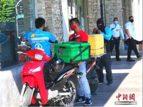 資料圖：4月4日，馬尼拉CBD馬卡蒂綠帶公寓外送快遞的小哥。<a target='_blank' >中新社</a>記者 關(guān)向東 攝