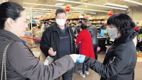 巴黎華助中心主任董曉燕(左)在歐拜赫維利耶一間華人超市發(fā)放口罩。(歐洲時(shí)報(bào))