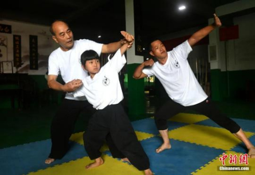 余丹秋指導(dǎo)9歲的鄭施澤學(xué)習(xí)鳴鶴拳。呂明攝