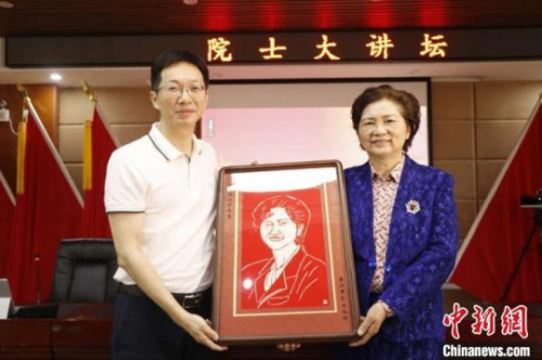　圖為晉江市衛(wèi)健局黨組副書記、市醫(yī)院院長陳銘向李蘭娟院士贈送剪紙作品?！∨ＰФY　攝