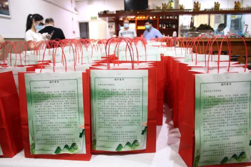 每一份粽子被裝在紅色的紙袋里，紙袋上還有一封“端午家書(shū)”。(受訪者供圖)