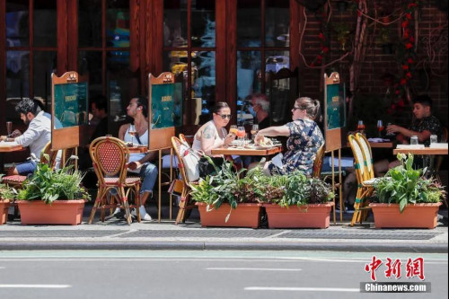 當(dāng)?shù)貢r(shí)間6月22日，紐約曼哈頓一家餐廳，顧客在戶外用餐。當(dāng)日，紐約市按預(yù)定計(jì)劃進(jìn)入第二階段重啟，市政府預(yù)計(jì)將有約30萬人重返工作崗位。<a target='_blank' >中新社</a>記者 廖攀 攝