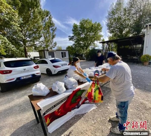 意大利華僑在佛羅倫薩擺攤，給有需要的當?shù)鼐用穹职l(fā)生活物資。　李偉康供圖