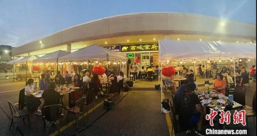 加拿大時間7月18日晚上，大多倫多地區(qū)華人聚居區(qū)萬錦市，一家中餐館開起了露天大排檔，不僅有燒烤啤酒，還有樂隊駐場演出。<a target='_blank' >中新社</a>記者 余瑞冬 攝