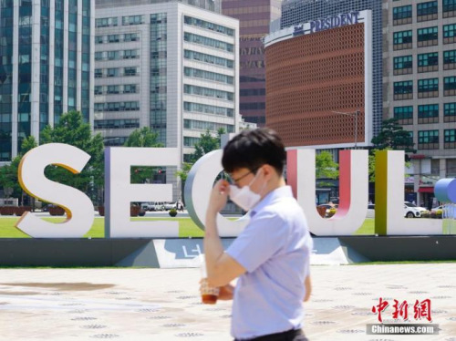 　6月23日，一位韓國首爾市民經(jīng)過首爾廣場。 <a target='_blank' >中新社</a>記者 曾鼐 攝