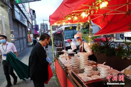 資料圖：當(dāng)?shù)貢r(shí)間8月16日晚，一家中餐廳在紐約法拉盛社區(qū)街道旁外賣菜肴。隨著紐約經(jīng)濟(jì)活動(dòng)的恢復(fù)，當(dāng)?shù)孛癖娨归g活動(dòng)逐漸增多。<a target='_blank' >中新社</a>記者 廖攀 攝