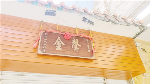這塊質(zhì)地堅硬的木質(zhì)“金聲”牌匾，默默見證著獅鼓行業(yè)的前世今生。